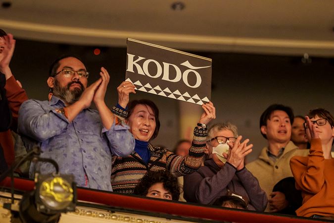 a fan in the balcony waves a Kodo sign