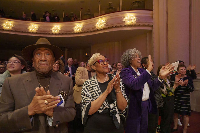 Audience members on the main floor give cheers and a standing ovation