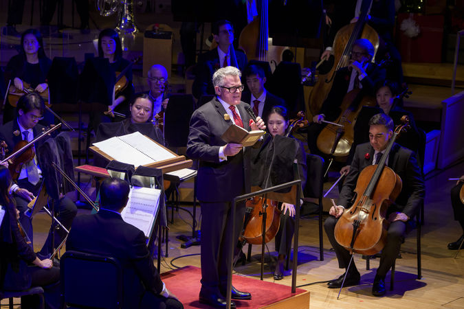 Closeup of conductor John Morris Russell speaking to the audience