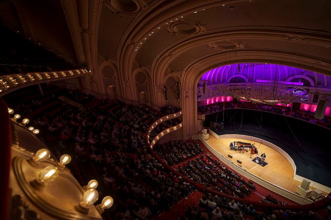 a view of the ensemble on stage from the point of view high up in the gallery