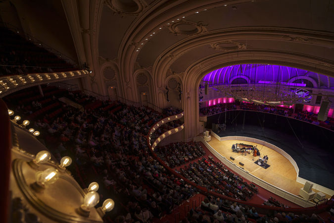 a view of the ensemble on stage from the point of view high up in the gallery
