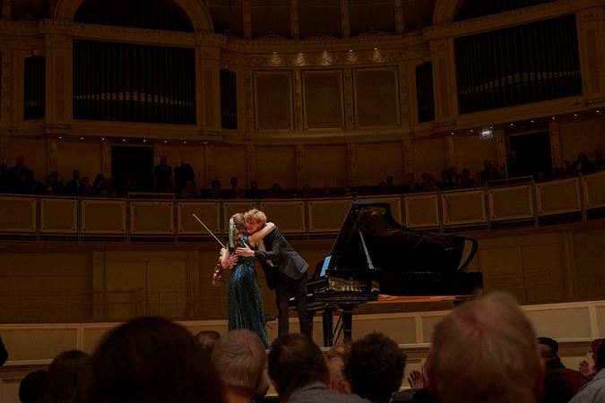 Violinist Julia Fischer and pianist Jan Lisiecki hugging on stage