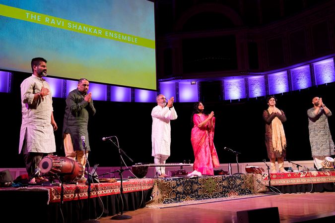 dressed in a mix of traditional Indian attire, the Ravi Shankar Ensemble takes a final bow after its performance