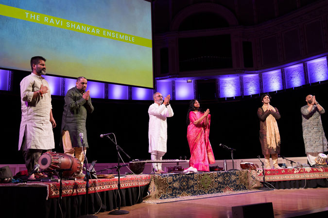 dressed in a mix of traditional Indian attire, the Ravi Shankar Ensemble takes a final bow after its performance