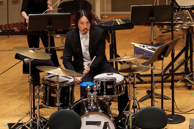 guest percussionist Ian Ding sits at the drum kit and focuses intently, waiting for his cue