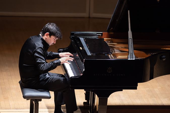 Behzod Abduraimov performs, head bowed over the keyboard