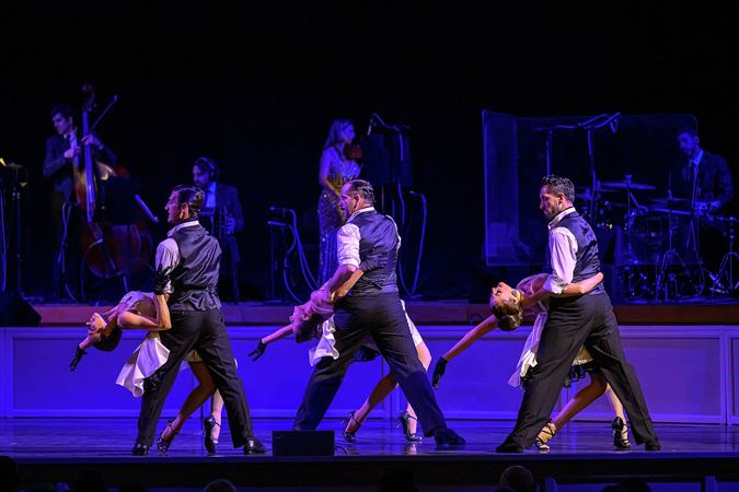 three tango couples dip their partners at the same time, creating a striking symmetrical picture