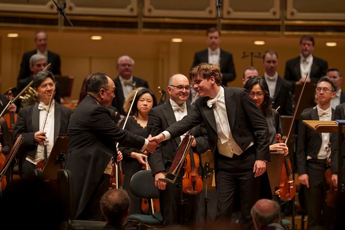 Klaus Mäkelä shakes hands with CSO concertmaster Robert Chen at the conclusion of the concert