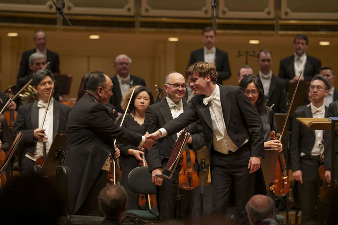 Klaus Mäkelä shakes hands with CSO concertmaster Robert Chen at the conclusion of the concert
