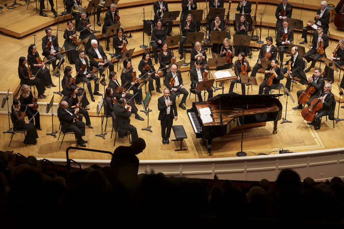 the audience looks down from the balcony as pianist Simon Trpčeski takes an encore bow