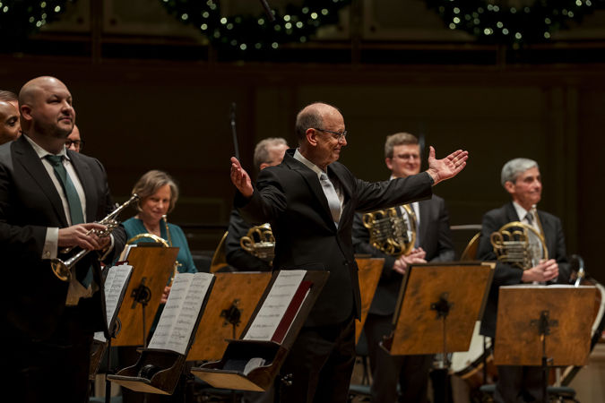 conductor Michael Mulcahy gestures for the ensemble to take a bow