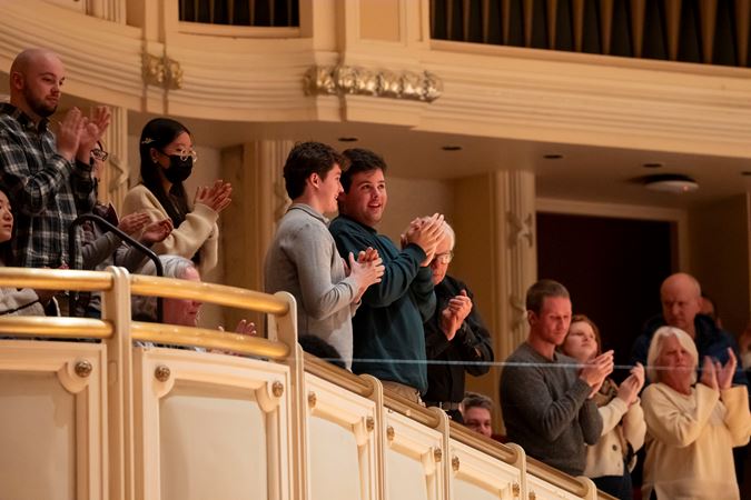Audience members clapping from the terrace
