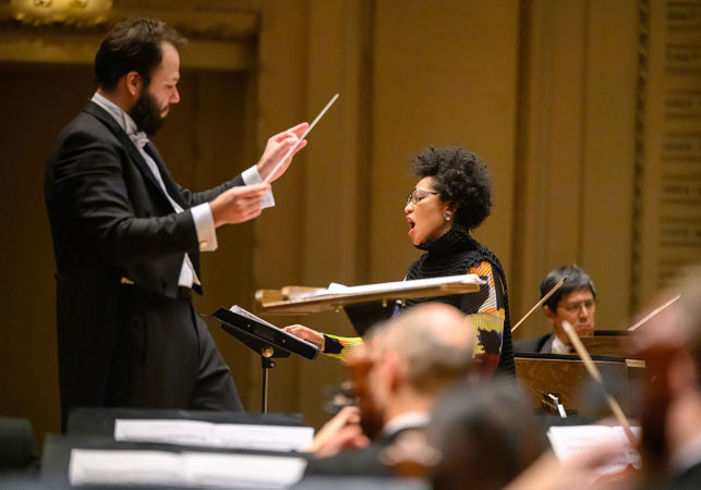 Petr Popelka raises his baton as Julia Bullock sings a passage of the world premiere piece, Song of the Reappeared