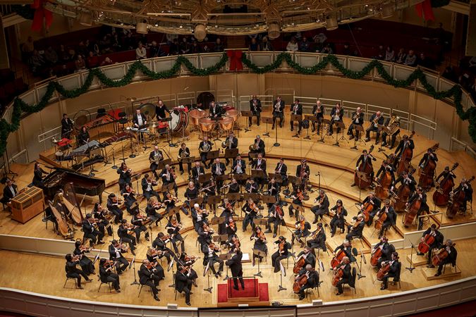a wide shot of the orchestra performing from above