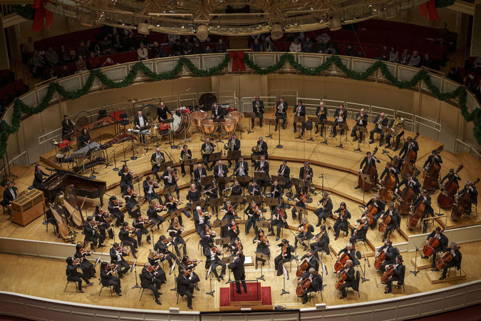 a wide shot of the orchestra performing from above