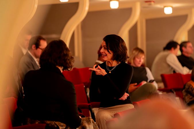 Closeup of three patrons chatting at their box level seats.