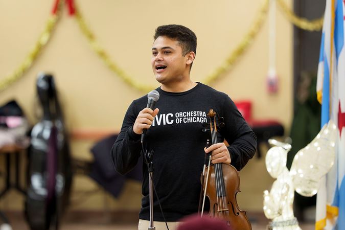 Civic violinist Ebedit Fonseca speaking to concert attendees at the Southwest Regional Senior Center during the 2025 Bach Marathon