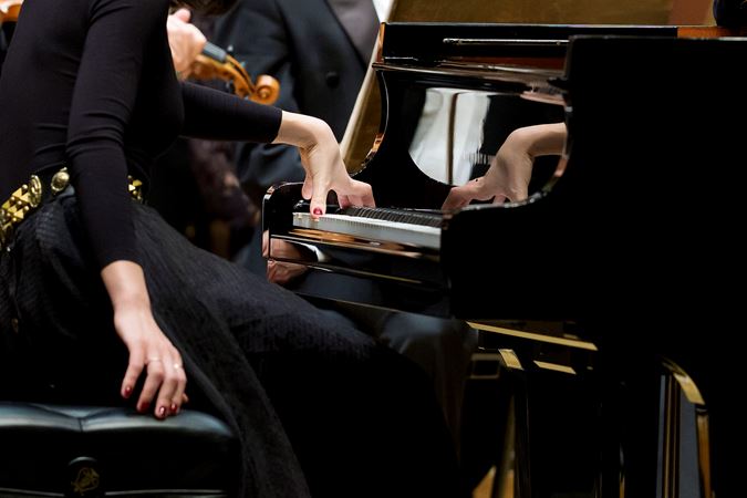 Closeup shot of pianist Alice Sara Ott's left hand on the keyboard