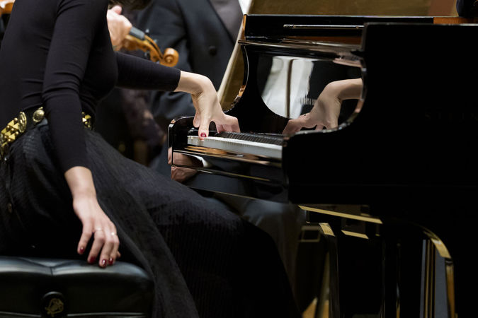 Closeup shot of pianist Alice Sara Ott's left hand on the keyboard