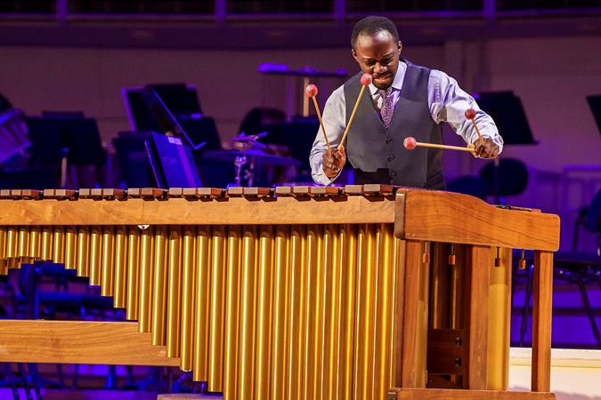 Action shot of Percussion Scholarship Program alum Josh Jones performing on stage