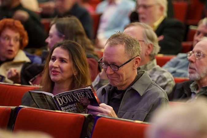 a couple in the audience passes time before the show by reading a copy of DownBeat jazz magazine