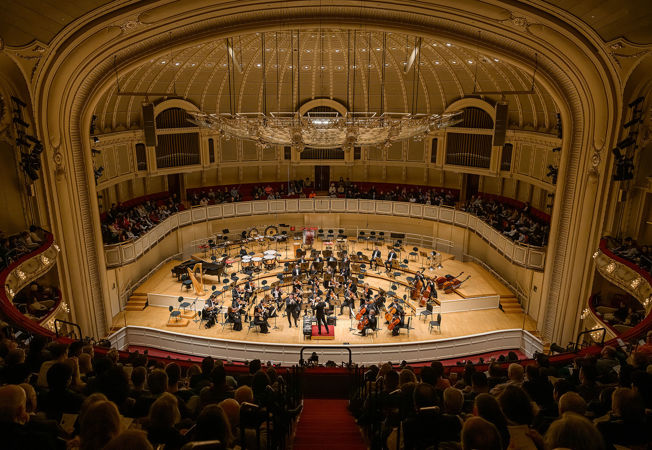 a view from the balcony of the full Sinfónica de Minería in performance