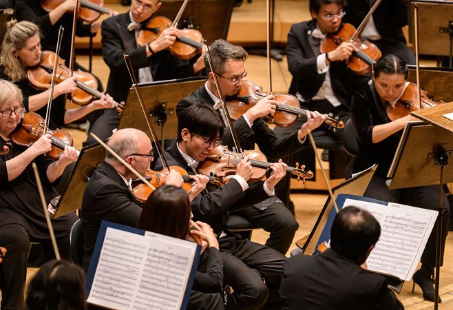 A close up of CSO violin and viola section performing on stage