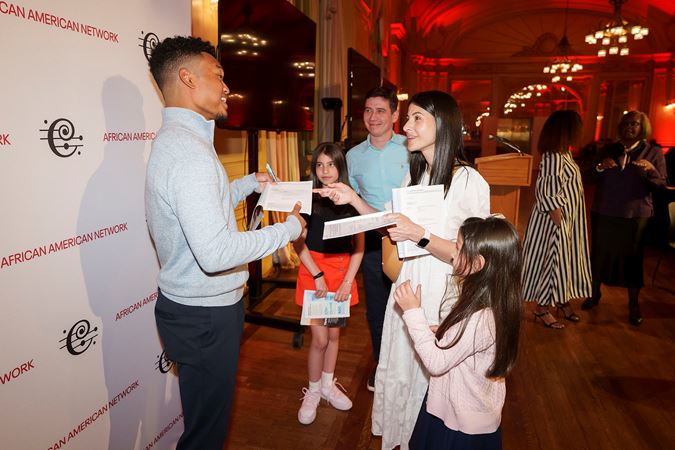 Violinist Randall Goosby signing programs at a Meet-and-Greet postconcert event in Grainger Ballroom hosted by the CSO African American Network