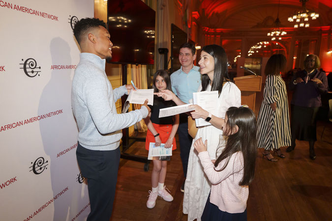 Violinist Randall Goosby signing programs at a Meet-and-Greet postconcert event in Grainger Ballroom hosted by the CSO African American Network