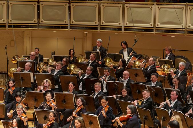 Group action shot of the CSO horn section raising their bells