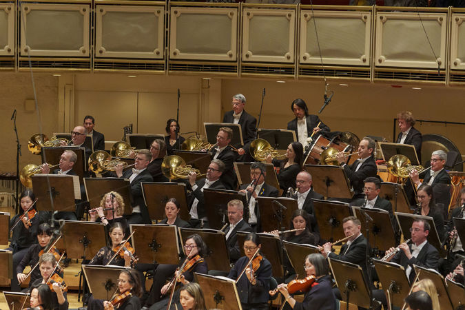 Group action shot of the CSO horn section raising their bells