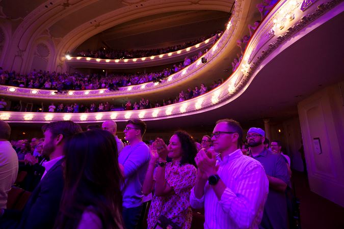 Wide shot of audience members applauding in Orchestra Hall