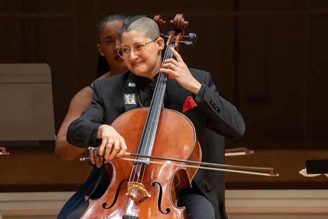 cellist Eri Snowden-Rodriguez smiles on stage
