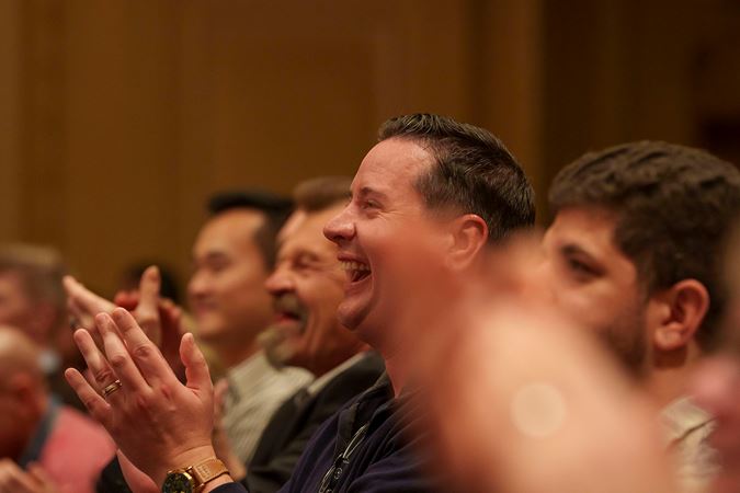 an enthusiastic audience member gives a standing ovation and an open-mouthed smile after Trpčeski's performance