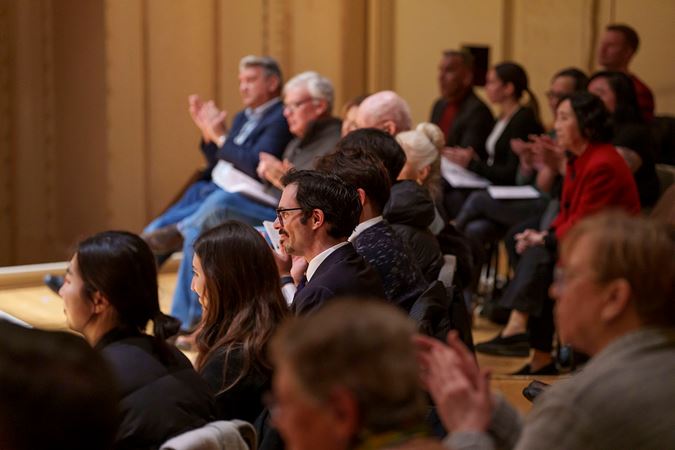 Audience members clapping on stage