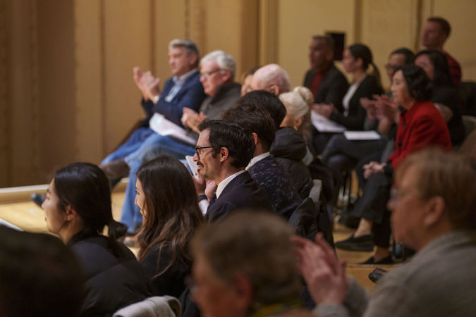 Audience members clapping on stage