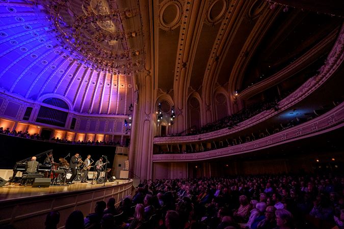 from the left side of the Main Floor, the enraptured audience looks on as the Unlimited Miles ensemble performs