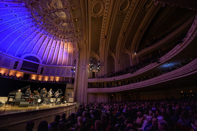 from the left side of the Main Floor, the enraptured audience looks on as the Unlimited Miles ensemble performs