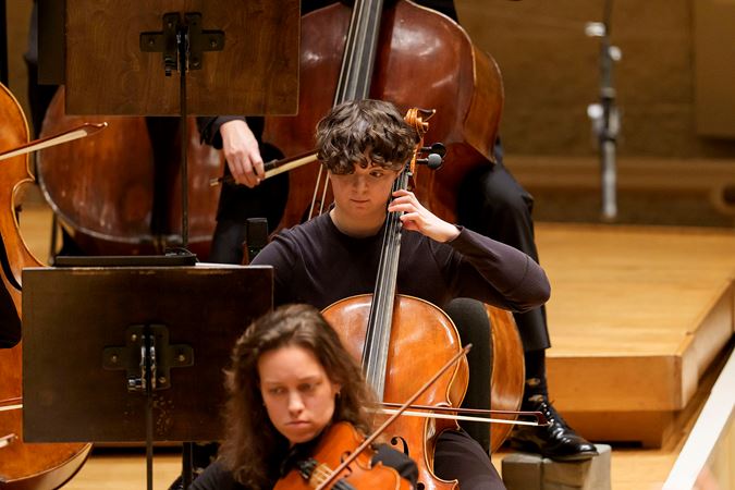 Closeup action shot of Civic Fellow J Holzen playing the cello