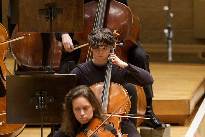 Closeup action shot of Civic Fellow J Holzen playing the cello