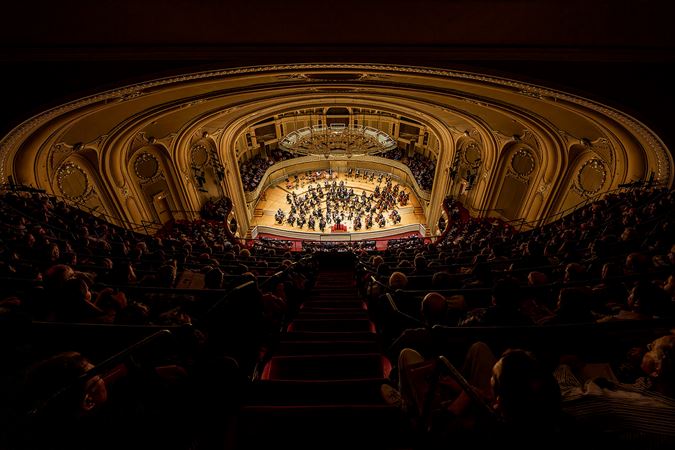 a wide shot of Orchestra Hall from the gallery, its top-most seating section, as a sea of people watch Muti and the CSO play Dvořák's beloved New World Symphony