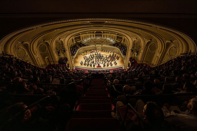 a wide shot of Orchestra Hall from the gallery, its top-most seating section, as a sea of people watch Muti and the CSO play Dvořák's beloved New World Symphony