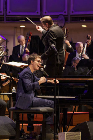Closeup action shot of singer-songwriter Ben Folds singing on stage at the piano with the CSO