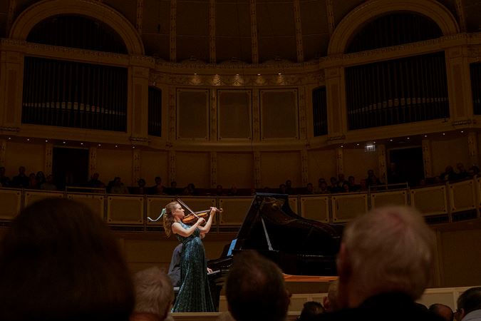 Action shot of violinist Julia Fischer performing on stage