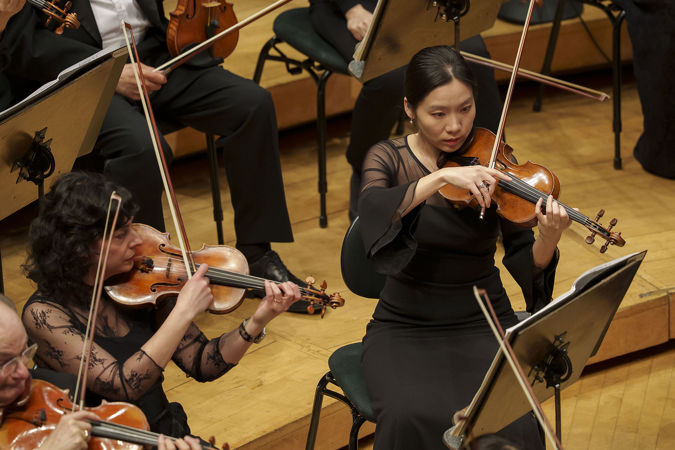 Closeup action shot of CSO violin players So Young Bae and Gina DiBello