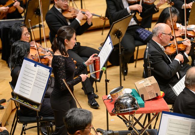 Cynthia Yeh strikes peculiar percussion instruments, including an upside down metal water bottle, during the Lost Coast concerto