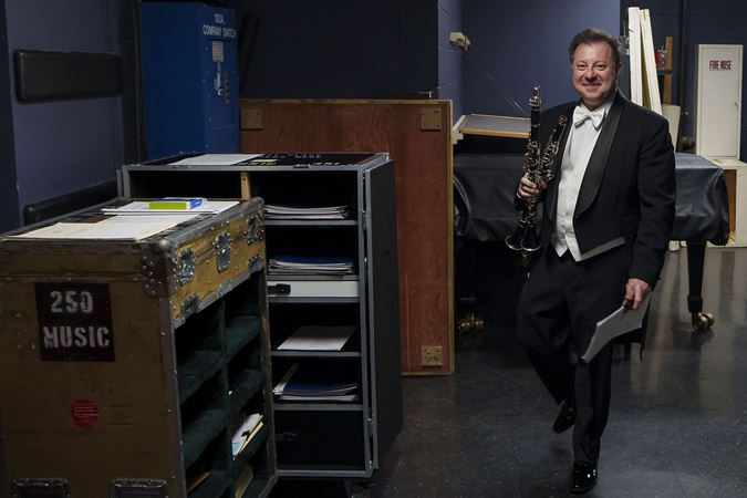 Stephen Williamson walks backstage with clarinets in hand to prepare for his solo