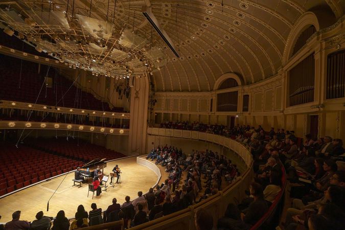 Wide shot of the Civitas Ensemble and the audience sitting on stage and in the terrace