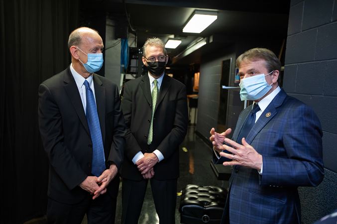 Michael Mulcahy (from left) and James Smelser speak with U.S. Rep. Mike Quigley (D-Ill.) after the concert.