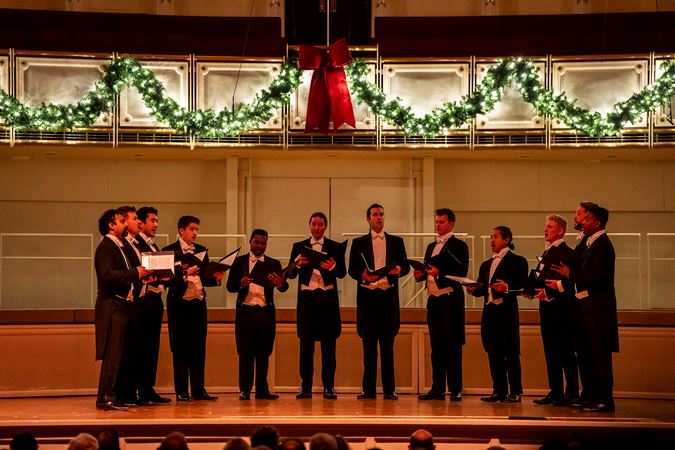 the members of Chanticleer sing under the dim holiday lights